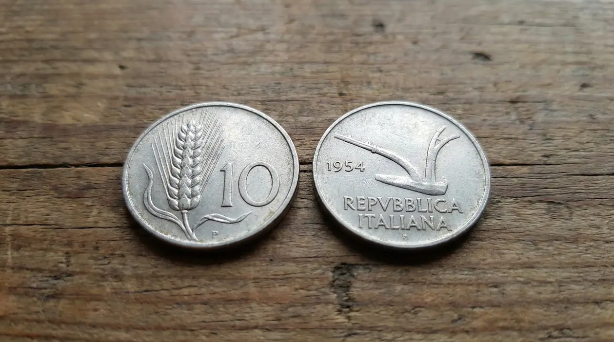 Due monete italiane da 10 lire del 1954 su un tavolo di legno